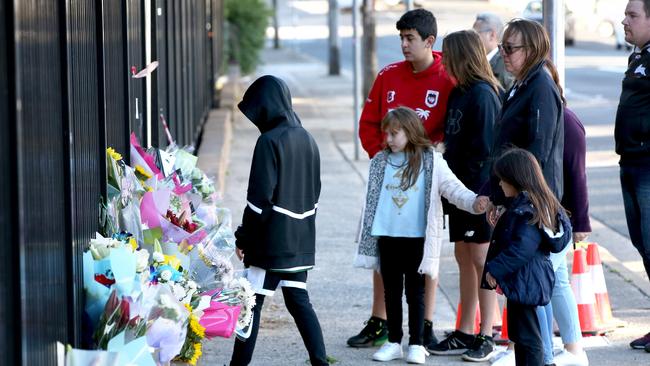 A family leaves flowers outside Hurstville Public School where the boy was hit last Friday. Picture: Damian Shaw