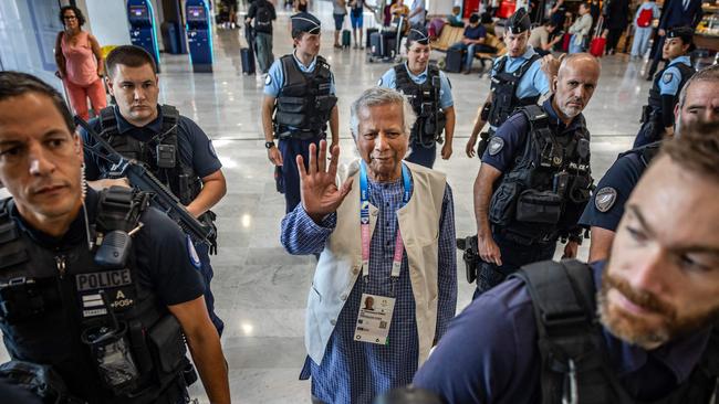 Muhammad Yunus is escorted by French police as he arrives at Roissy-Charles de Gaulle Airport near Paris on Wednesday. Picture: AFP