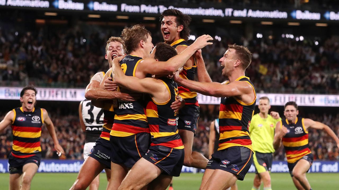 ADELAIDE, AUSTRALIA - APRIL 01: Players surround Jordan Dawson of the Crows after kicking the winning goal during the 2022 AFL Round 03 match between the Adelaide Crows and the Port Adelaide Power at Adelaide Oval on April 01, 2022 In Adelaide, Australia. (Photo by Sarah Reed/AFL Photos via Getty Images)