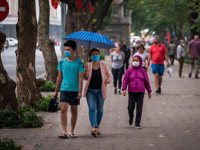 People wear face masks amid concerns of the spread of the coronavirus (COVID-19) while walking in Hanoi, Vietnam. Picture: Getty