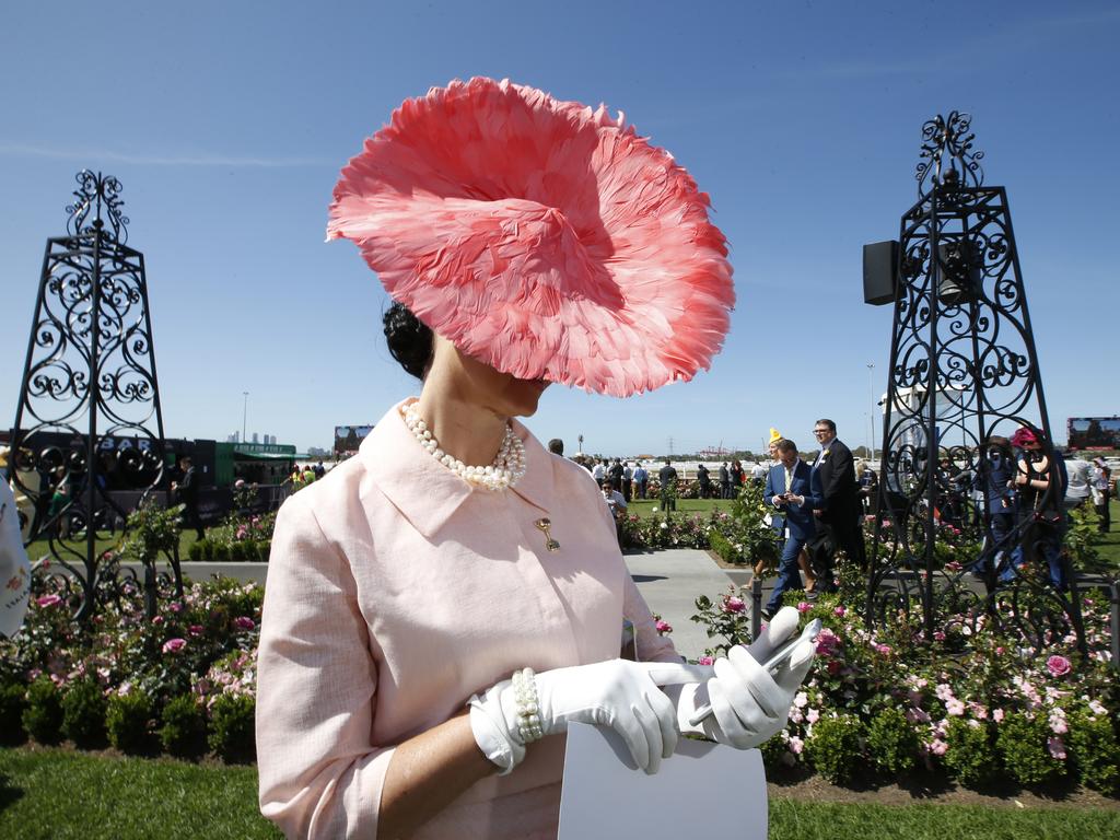 Angela McCormick wearing a Julie Casey hat checks her phone while in line for judging. Picture: David Caird.