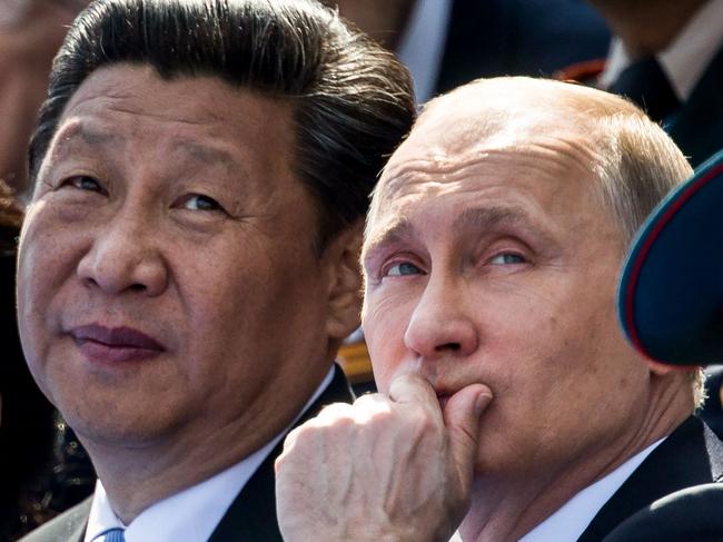 (FILES) In this file photo taken on May 09, 2015, Russian President Vladimir Putin (R) and Chinese President Xi Jinping watch the Victory Day military parade at the Red Square in Moscow. - Chinese President Xi Jinping begins a state visit to Russia on March 20, 2023, a trip Beijing has touted as a "visit for peace" as it seeks to play mediator in Vladimir Putin's war in Ukraine. (Photo by ALEXANDER ZEMLIANICHENKO / POOL / AFP)