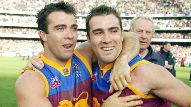 Champions Chris and Brad Scott celebrate their 2002 Grand Final win.