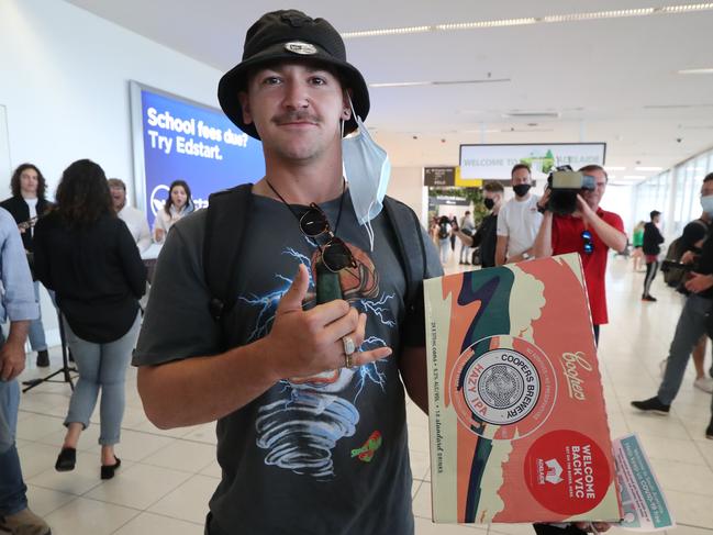 Joel Astle, who arrived from Melbourne this morning, was happy to grab a free carton of Coopers. Pic Tait Schmaal.