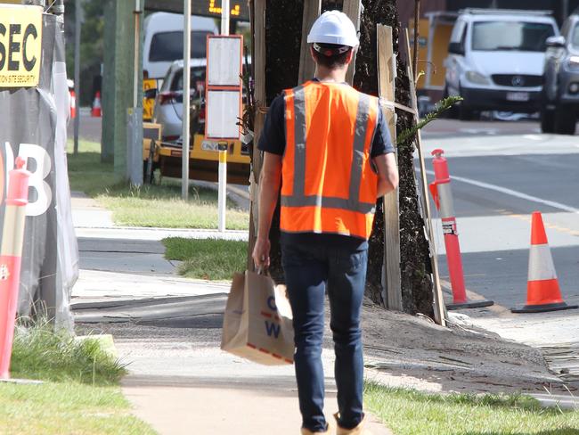 A workmeman arrives at the Shoreline tower construction site at 61 Old Burleigh Rd to find it locked up as builder PBS is rumoured to have gone into liquidation. Picture Glenn Hampson