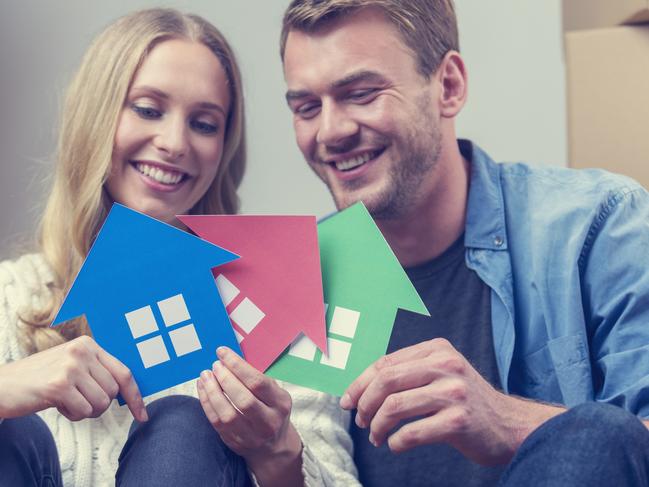 Leader Hot Topic - should you buy a second house - iStock stock photo couple with multiple homes, property investment, house purchaseCouple with 3 house symbols Ã¢Â€Â“ choice concept. They are sitting down, smiling, both casually dressed and holding green, blue and red house symbols which could represent also environmental conservation or home ownership, or property development.