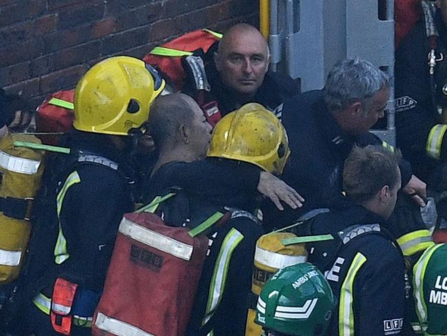 ‘Listen to me.’ A man is rescued by fire fighters from the burning building. Picture: Getty Images