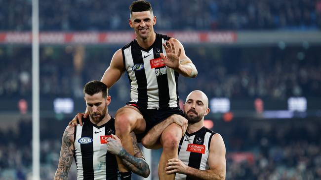 MELBOURNE, AUSTRALIA - AUG 03: Scott Pendlebury of the Magpies is chaired off the ground by teammates Jeremy Howe (L) and Steele Sidebottom (R) after his 400th game during the 2024 AFL Round 21 match between the Collingwood Magpies and the Carlton Blues at The Melbourne Cricket Ground on August 03, 2024 in Melbourne, Australia. (Photo by Dylan Burns/AFL Photos via Getty Images)