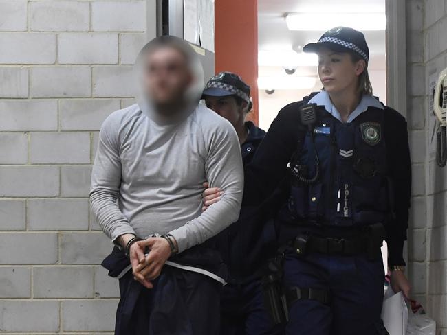 A man is led into Kogarah Police Station last night after his arrest. Picture: Gordon McComiskie