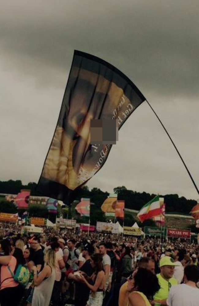 Awkward ... A festival goer waves a flag with an image from Kim Kardashian’s sex tape while her husband performs. Picture: Instagram/Luke Hopson