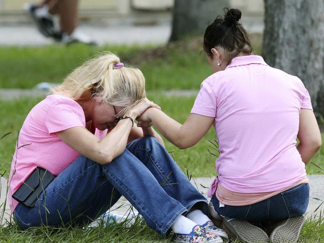 Two women console each other near the high school. Picture: Jennifer Reynolds /The Galveston County Daily News via AP