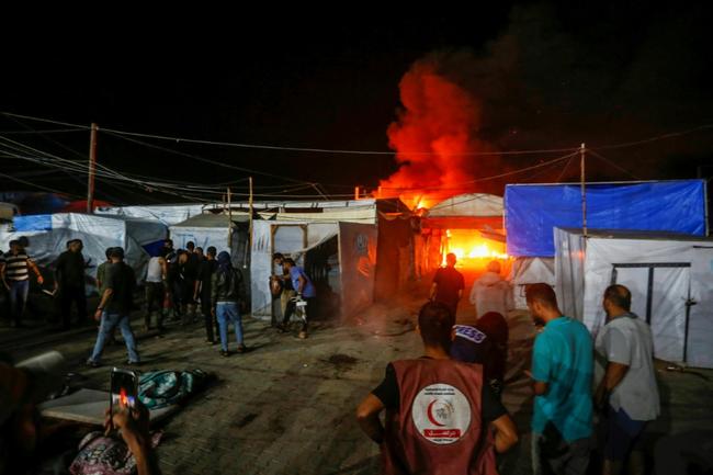 A picture provided by the United Nations agency for Palestinian refugees (UNRWA) shows the site of an Israeli air strike around tents for displaced people inside the walls of Al-Aqsa Martyrs Hospital in Deir El-Balah, central Gaza