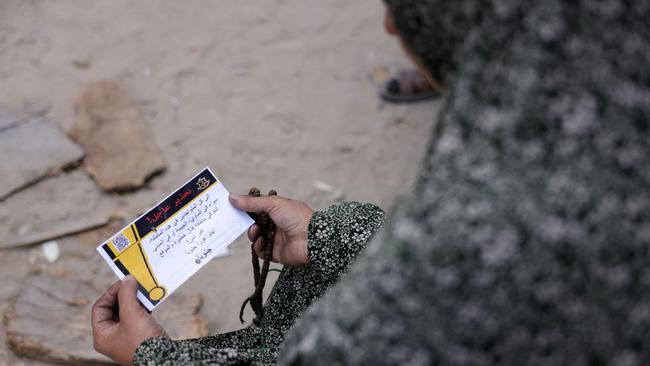 A Palestinian woman holds a leaflet dropped by the Israeli army, warning people in Jabalia in the Northern Gaza Strip to flee toward the southern part of the territory. Picture: AFP