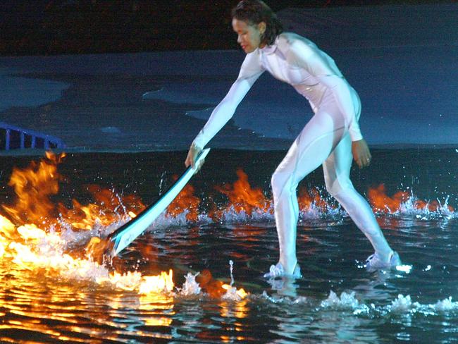 ##AFP PIC FEE PAYABLE CHECK BEFORE USE##  Australian athlete Cathy Freeman stands on water and lights the Olympic cauldron with the torch 15 Sept 2000 during the /Sydney Olympic Games Opening Ceremony to ignite the 27th Olympiad of the modern era, PicKazuhiro/NOGI sport athletics olympics olympic2000 sydney2000 flame flames torchbearer