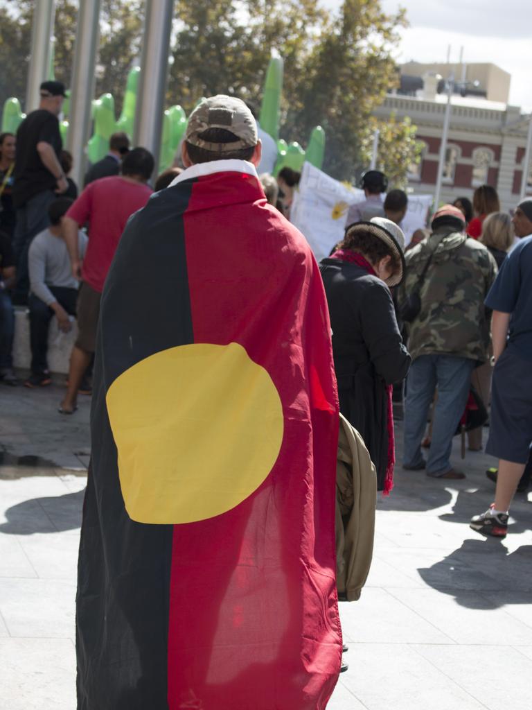 Perth, Australia – March 19, 2015: Man with the Aboriginal flag draped around his shoulders during a protest.