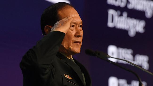 China's Defence Minister Wei Fenghe salutes from the podium at the Shangri-La Dialogue summit in Singapore on Sunday. Picture: AFP