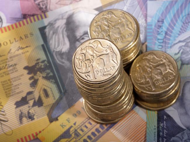 Three stacks of Australian one dollar coins on a background of bank notes. Shallow depth of field focus on tallest stack., cash money generic