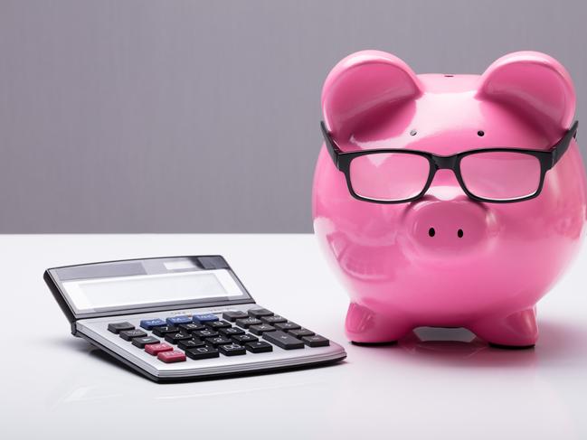 Close-up Of A Piggybank With Eyeglasses And Calculator On Desk; investing superannuation money calculations generic