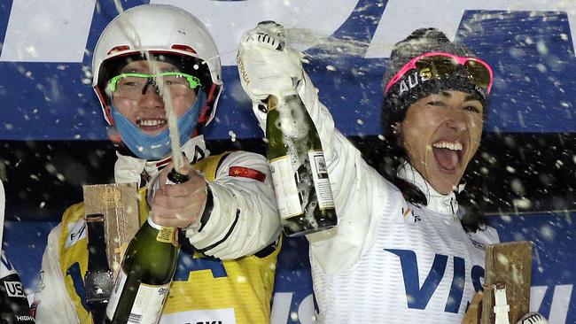 First-place finishers Lydia Lassila, right, of Australia, and Qi Guangpu, left, of China, celebrate on the freestyle skiing World Cup podium.