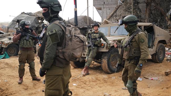 Soldiers idling outside a school once used by Hamas in Khan Younis. Picture: Yoni Bashan / The Australian