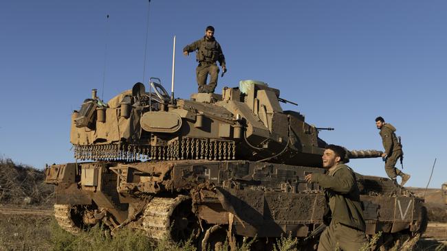 sraeli soldiers stand near a tank as it is moving along the border with Lebanon. Picture: Getty Images