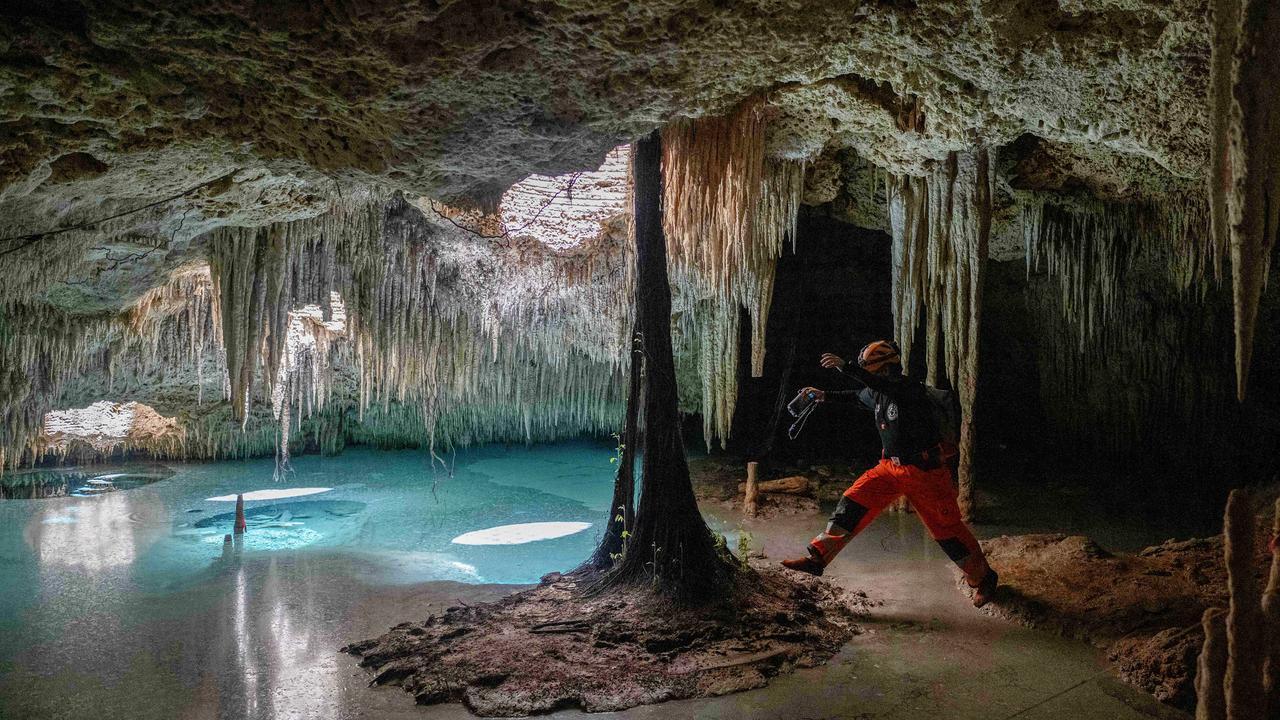 Environmental activist Guillermo D’Christy leaps over water in a cenote near Playa del Carmen, Mexico. The cenotes, pre-Hispanic underground wells in the Yucatán Peninsula, are threatened by the Mayan Train megaproject to promote tourism. Picture: Carl De Souza/AFP