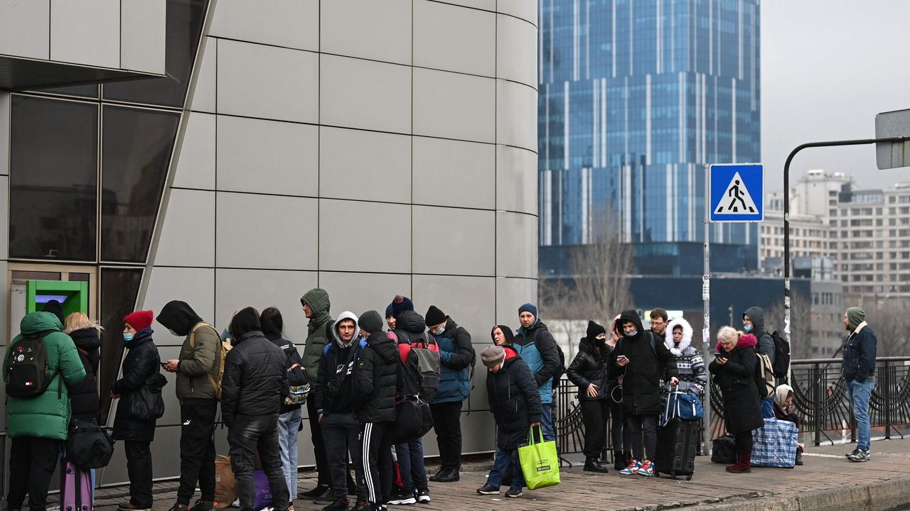 People line up to withdraw money at a cash dispenser in Kyiv. Picture: Daniel Leal / AFP