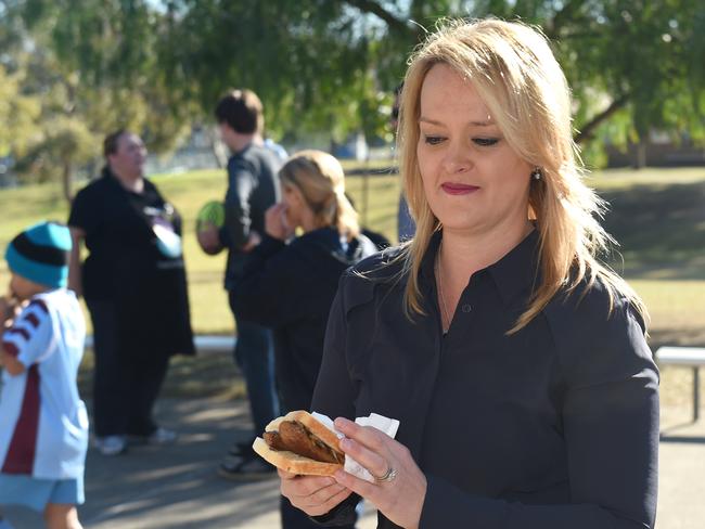 The taste of defeat? Fiona Scott assesses a sausage sandwich after casting her vote. Picture: AAP Image/Paul Miller