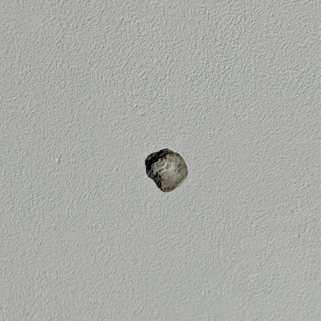 Damage from a bullet in the wall of the next door property.