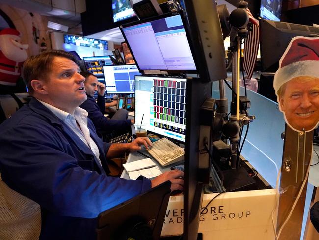 An image of US President-elect Donald Trump is displayed as traders and financial professionals work on the floor of the New York Stock Exchange (NYSE) at the opening bell on November 26, 2024, in New York City. (Photo by TIMOTHY A. CLARY / AFP)