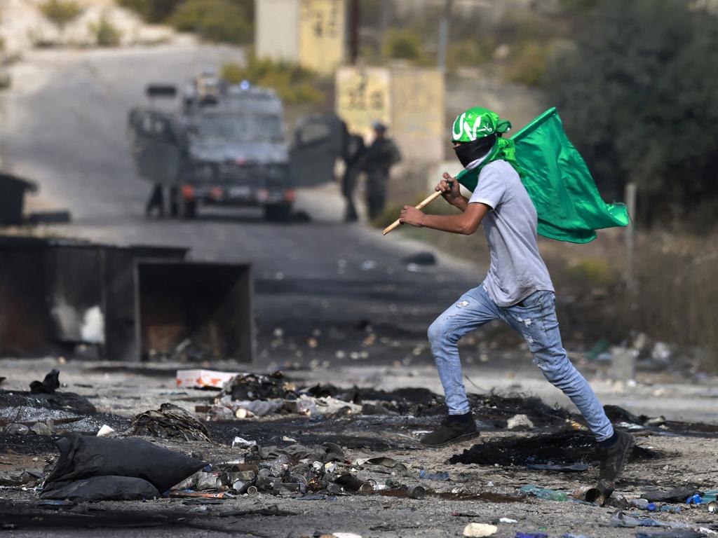 A Palestinian youth waves a Hamas flags during confrontations with Israeli troops at the northern entrance of the West Bank city of Ramallah near the Israeli settlement of Beit El on Friday. Picture: AFP