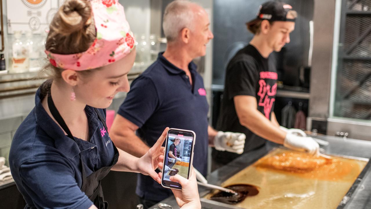 Annabelle takes a photo of her dad and another employee for a TikTok video.