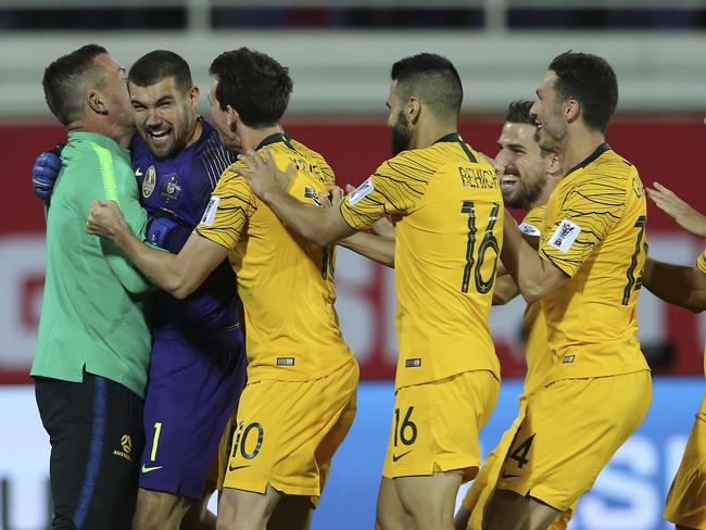 Australian players celebrate with their goalkeeper Mat Ryan.