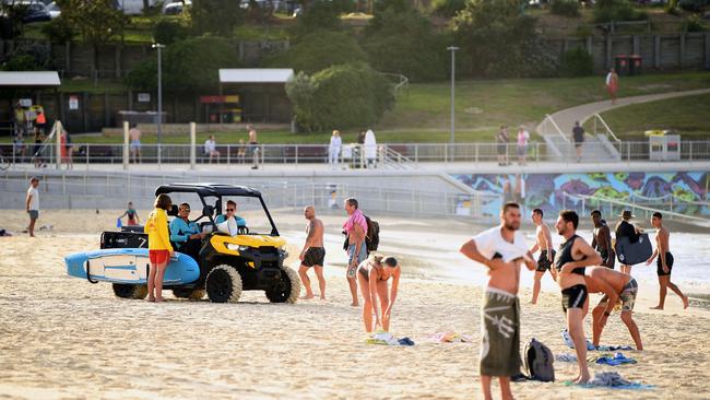 Lifeguards ask people to leave the sand at Bondi Beach in Sydney on Sunday.