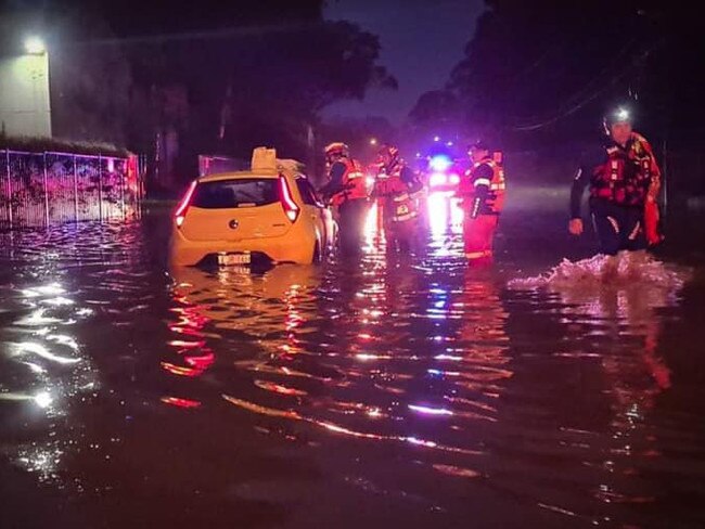 Penrith SES volunteers are seen assisting another car driving through flood waters. Picture: Penrith SES