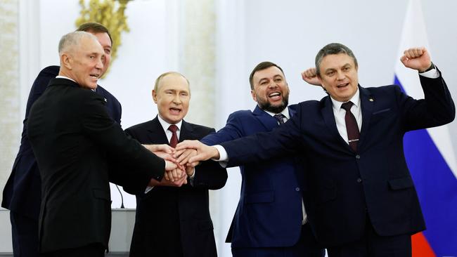 The Moscow-appointed heads of Kherson region Vladimir Saldo and Zaporizhzhia region Yevgeny Balitsky, Russian President Vladimir Putin, Donetsk separatist leader Denis Pushilin and Lugansk separatist leader Leonid Pasechnik join hands after signing treaties formally annexing four regions of Ukraine Russian troops occupy.