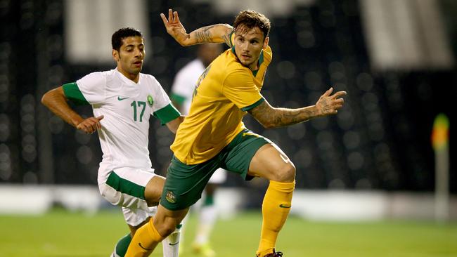 Taiseer Aljassam of Saudi Arabia tries to tackle Chris Herd of Australia during the International Friendly match between Saudi Arabia v Australia at Craven Cottage on September 8, 2014 in London, England. (Photo by Ian Walton/Getty Images)