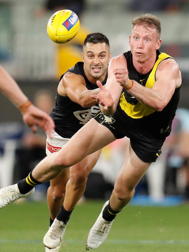 Dylan Grimes gets a handpass away against Michael Gibbons. Picture: Getty Images