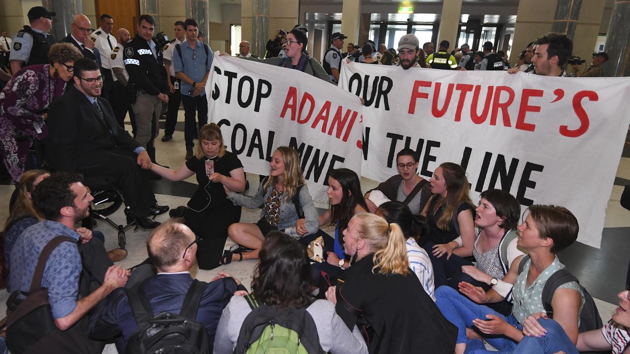 Greens Senator Jordan Steele-John (left) is seen with students and activists during a sit-in protest in the marble foyer at Parliament House. Picture: Lukas Coch/AAP