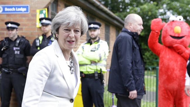 Elmo photo bombs Theresa May as she leaves a polling station in Maidenhead after voting. Picture: AP.