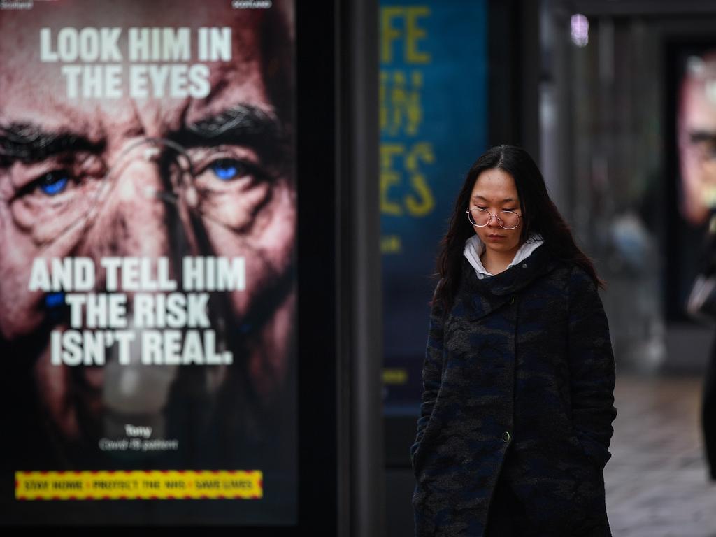 Members of the public walk past a government poster reminding people to socially distance and abide by the lockdown restrictions in Edinburgh, Scotland. Picture: Jeff J Mitchell/Getty Images