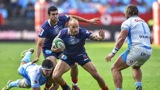 Rebels' Billy Meakes (2nd R) runs as Bulls' Marco van Staden (L) dives to tackle him during the Super Rugby rugby union match between South Africa's Bulls and Australia's Rebels at the Loftus Versfeld Stadium in Pretoria on April 21, 2018. / AFP PHOTO / Christiaan Kotze