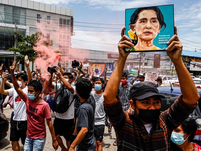 A protester holds up a painting of Myanmar's detained civilian leader Aung San Suu Kyi to mark her birthday during a demonstration against the military coup in Yangon on June 19, 2021. (Photo by STR / AFP)