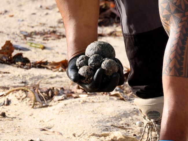 SYDNEY, AUSTRALIA - NewsWire Photos OCTOBER 16, 2024: Council workers clean up what Randwick council describes as possible tar balls that have washed up on Coogee Beach. Coogee Beach has been closed until further after mysterious, black, ball-shaped debris was located washed along the length of the beach.Picture: NewsWire / Damian Shaw