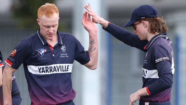 Mitch Cross and his Yarraville teammates celebrate a wicket. Photo: Hamish Blair