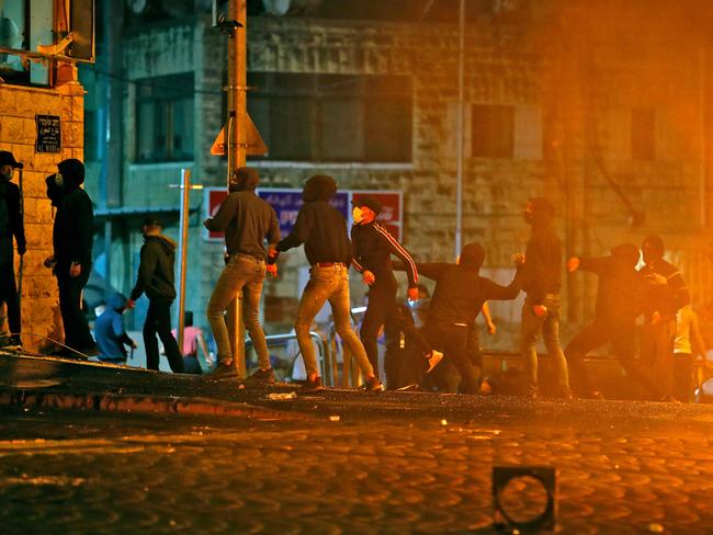 Palestinian protesters hurl stones during clashes with Israeli forces in the Shuafat camp for Palestinian refugees, neighbouring the Israeli settlement of Ramat Shlomo. Picture: AFP