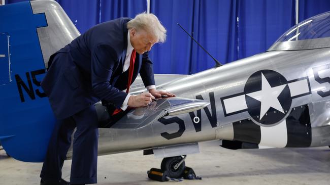 Former President Donald Trump signs North American Aviation P-51 Mustang at a campaign rally at Gastonia Municipal Airport on November 02 in Gastonia, North Carolina. Picture: Getty Images