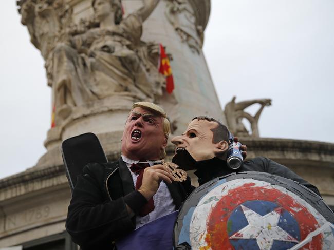 Protesters wearing a Donald Trump mask, left, and an Emmanuel Macron mask act up for the cameras during an anti-Trump gathering in Paris. Picture: AP