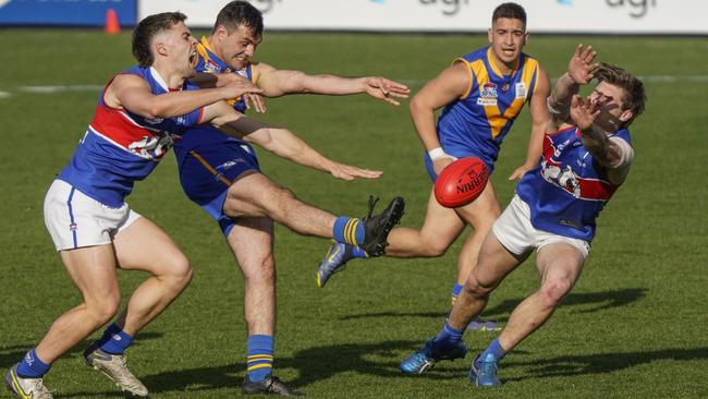 SFL: Cranbourne’s Jake Carosellan gets a kick away under pressure. Picture: Valeriu Campan