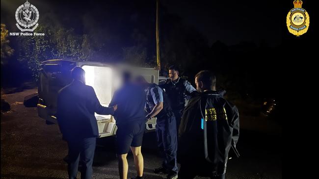 Desmond Jethro Higgins being led away by authorities after the dawn raid at Waratah on Friday. Picture: ABF.